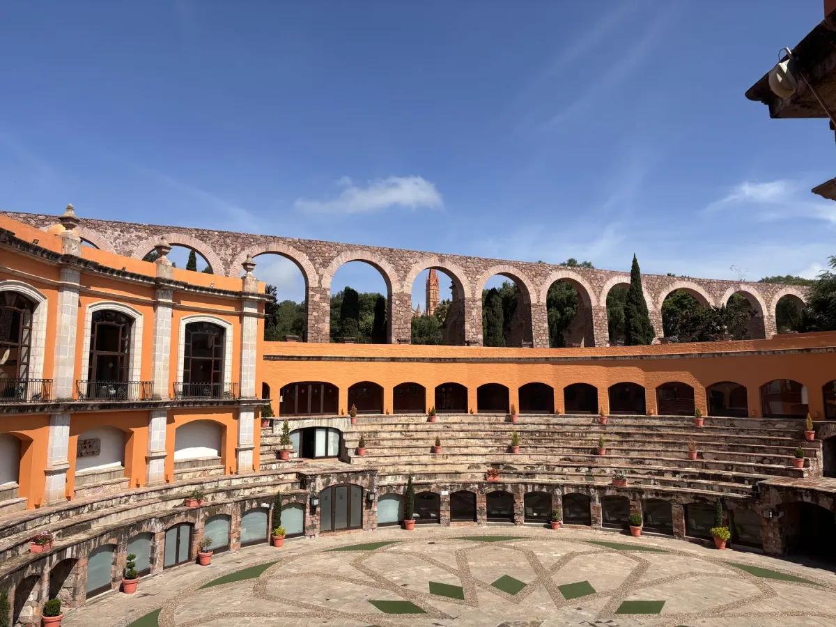A sunny colonial courtyard with arches and plants in Mexico