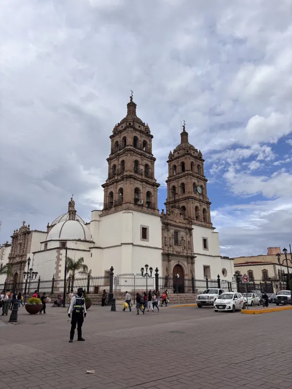 A twin-towered cathedral and a busy plaza in Mexico